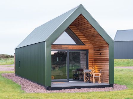 A cabin with a deck and table outside at The Weir in North Berwick