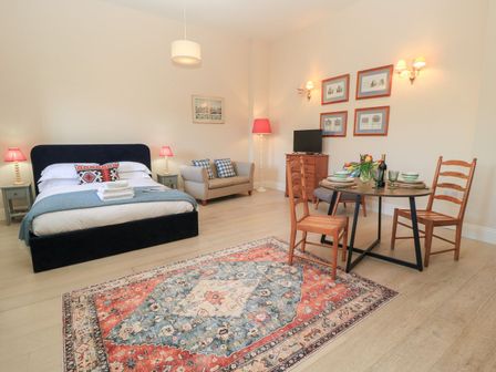A studio with a bed sofa and dining table at Swallow Studio in Andoversford near Cheltenham