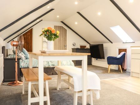 A bedroom with a bed, table, and chair at Thomas Chambers in Camborne