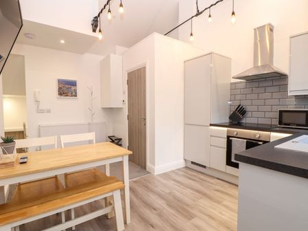 A kitchen with dining table and chairs at Battell Chambers in Camborne