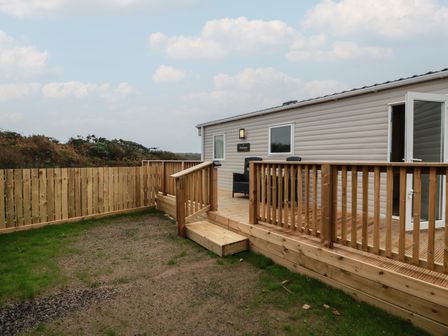 An outdoor area with decking and a building at Ellies House in Stranraer