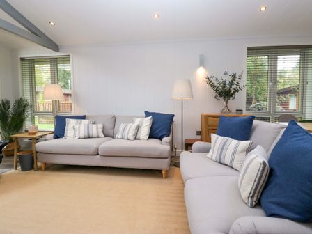 A living room with a sofa and cushions at 5 Waterside Wood Troutbeck Bridge