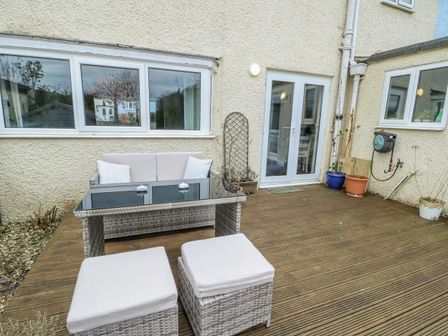 An outdoor patio with a sofa and table at 16 Ffordd Meigan Beaumaris