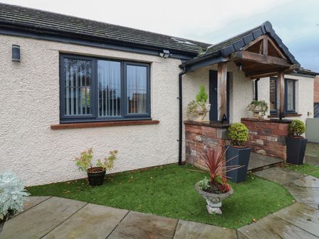 An exterior view of a house with a porch and planters at Cobble Cottage Long Marton near Appleby-In-Westmorland