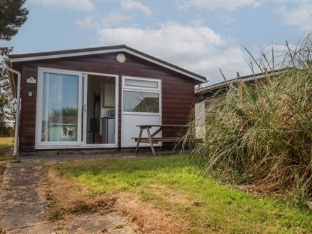 A cabin with a table and grass at Stanbury in St Merryn