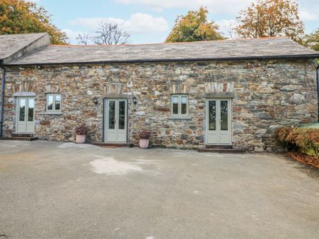An exterior view of a stone building with doors and windows at Robins Rest at The Lodge Kilmacthomas