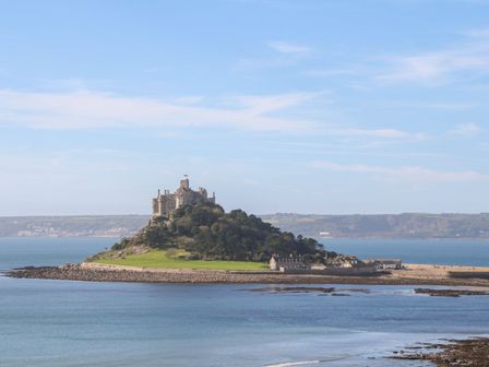 A view of a castle on a hill by the water at Sea Whispers in Marazion