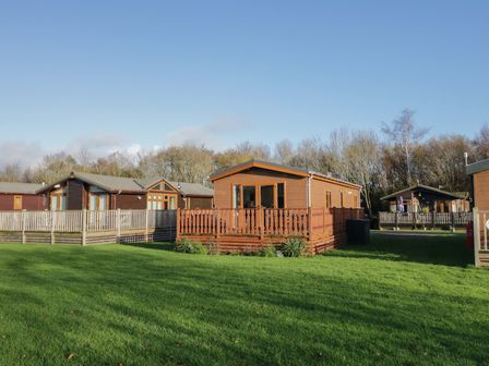A view of cabins with decking in an outdoor area at Bluebell Lodge in Warton
