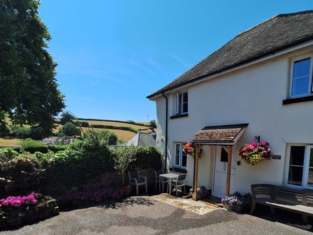 A house with flowers near the entrance at Orchard Cottage in Holcombe