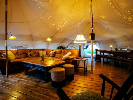 A living room with a sofa and table in a tent