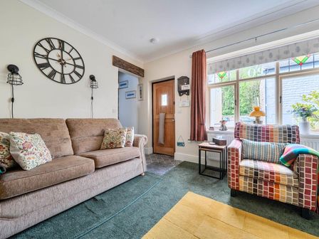 A living room with a sofa and armchair at 20 Main Street in Heysham