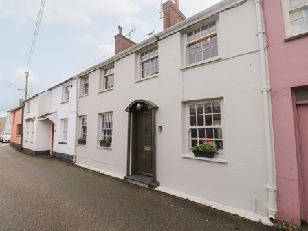 A row of houses with windows and planters at The Music Box in Beaumaris