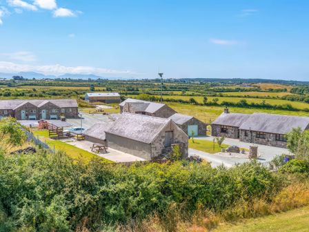 An outdoor area with buildings and fields at Kestrel Cottage in Llangaffo