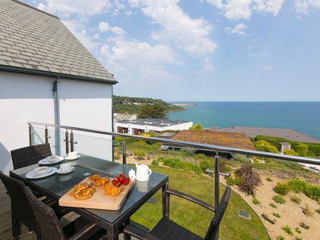 A balcony with a table and chairs overlooking the sea at Mid Air St. Ives