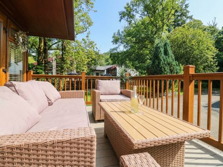A patio with a sofa and coffee table at Terabitha Lodge in Troutbeck