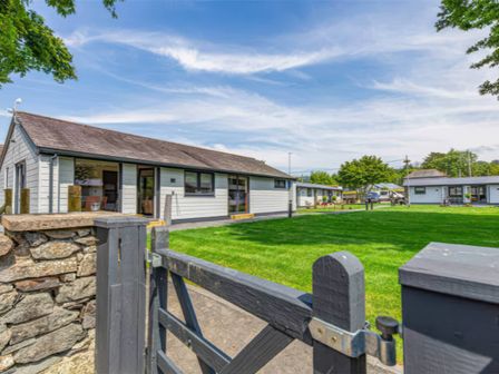 A house with a gate and grass area at Silver Birch Cottage in Llanrwst