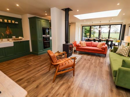 A living room with a stove and sofas at Fairview in Darsham