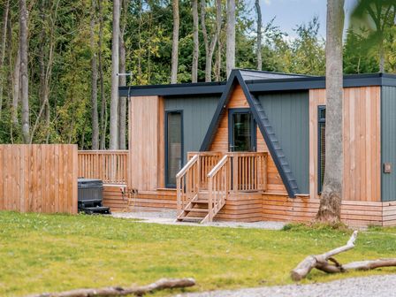 A cabin with wooden deck and steps at Tennyson Spa in Louth