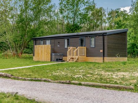A cabin with a hot tub and pathway at Horncastle Spa Plus (Pet) in Louth