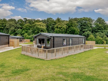A cabin with decking surrounded by grass and trees at Alford WF in Louth