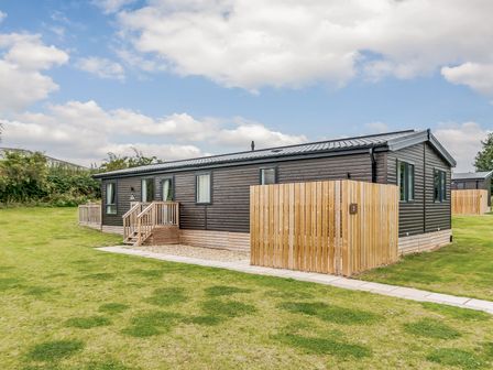 A modular building with a lawn and fence at Brayford Lodge in Louth