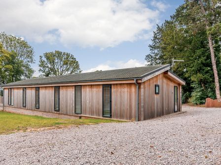 A wooden building with windows and a door at Retreat Lodge 4 in Louth