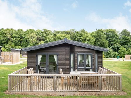 A holiday lodge with a deck and seating area at Brayford Lodge Spa in Louth