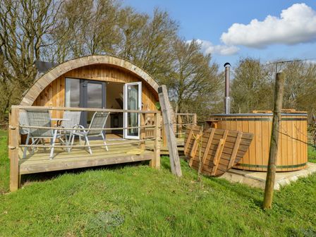 A cabin with a deck and hot tub at Grape Escape near Halesworth