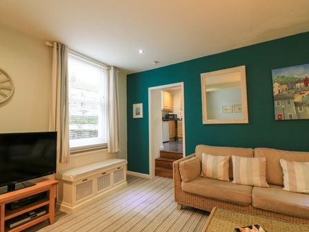 A living room with a television and sofa at Smugglers Cove in Dartmouth