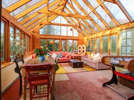 A conservatory with seating and plants at Town Farm in