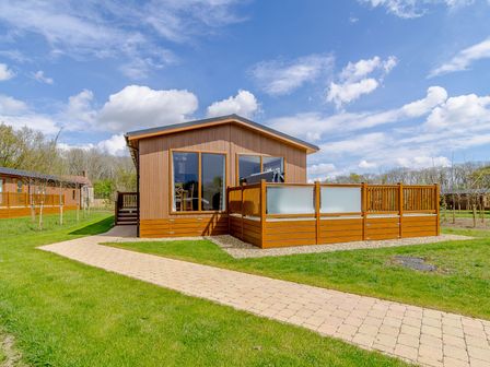 A lodge with a deck and pathway at The Yarwell (Pet) Kings Cliffe