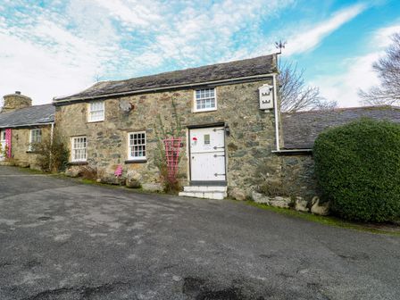 A stone house with front door and windows at The Mill in Holyhead