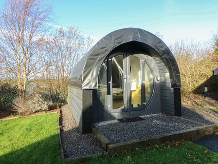 A circular building with a door and windows at Garden Lodge 9 Swansea