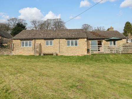 A house with a grassy area and an umbrella at Daisy Bank in Maugersbury near Stow-On-The-Wold