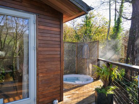 An outdoor area with a jacuzzi and wooden deck at 6 Stonerush Valley Looe