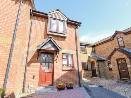 An exterior view of a brick house with a door and windows at Harbour View Poole