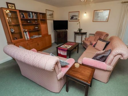 A living room with sofas and a coffee table at Grange Cottage in Belford
