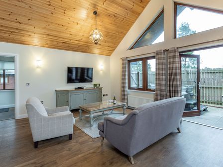 A living room with a sofa and coffee table at Byron Premier Spa (Pet) in Dundee