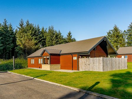 A cabin with windows and a fenced area at Galbraith Premier Spa in Dundee