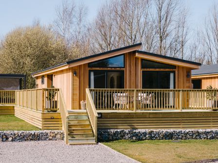 A cabin with a wooden deck and outdoor seating at Moonlight Spa Luxury in Waltham