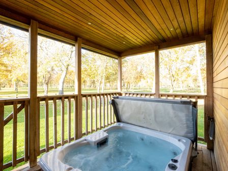 An outdoor area with a hot tub on a wooden deck at Wentworth in Waltham