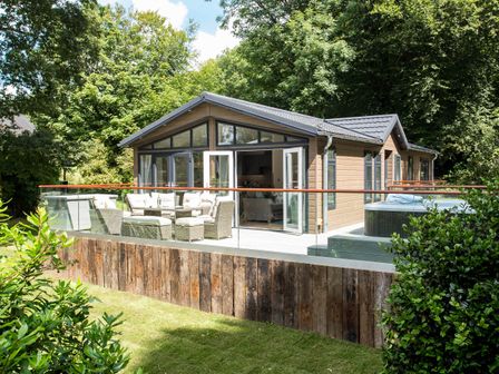 A garden with outdoor seating and a hot tub at Aubyn Lodge Spa in Praze-An-Beeble
