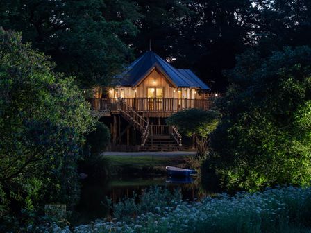 A treehouse with lights on at The Treehouse in Praze-An-Beeble