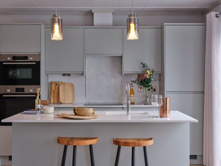 A kitchen with an island and bar stools at Epic Spa (Pet) in Laugharne