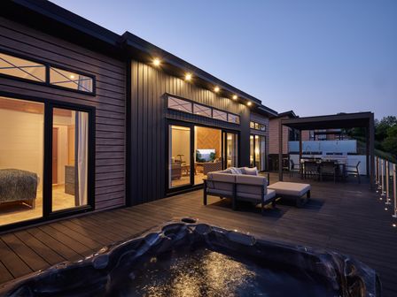 A deck with a hot tub and outdoor seating at Canto Spa in Laugharne