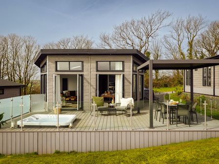 A deck with hot tub and seating area at Apex Spa (Pet) in Laugharne