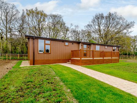A cabin with a deck and pathway at The Fotheringhay in Kings Cliffe