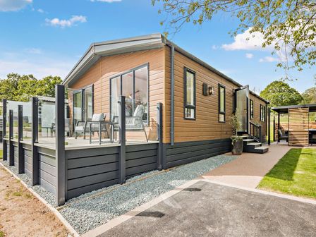 A house with a deck and chairs at Saron 2.0 Spa Pet in Llandyrnog