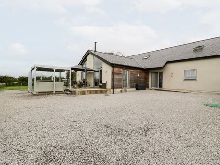 A house with a patio and outdoor seating at Cae Sam in Pentraeth