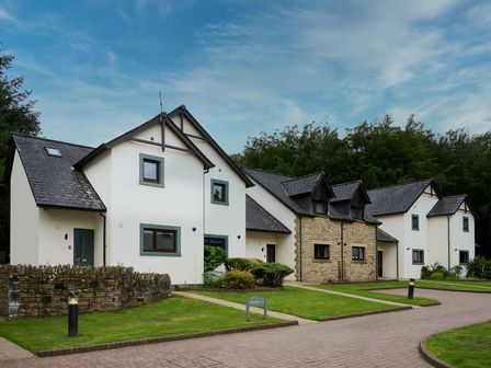 A row of houses with a pathway and garden at Troutbeck Cottage Spa in Penrith